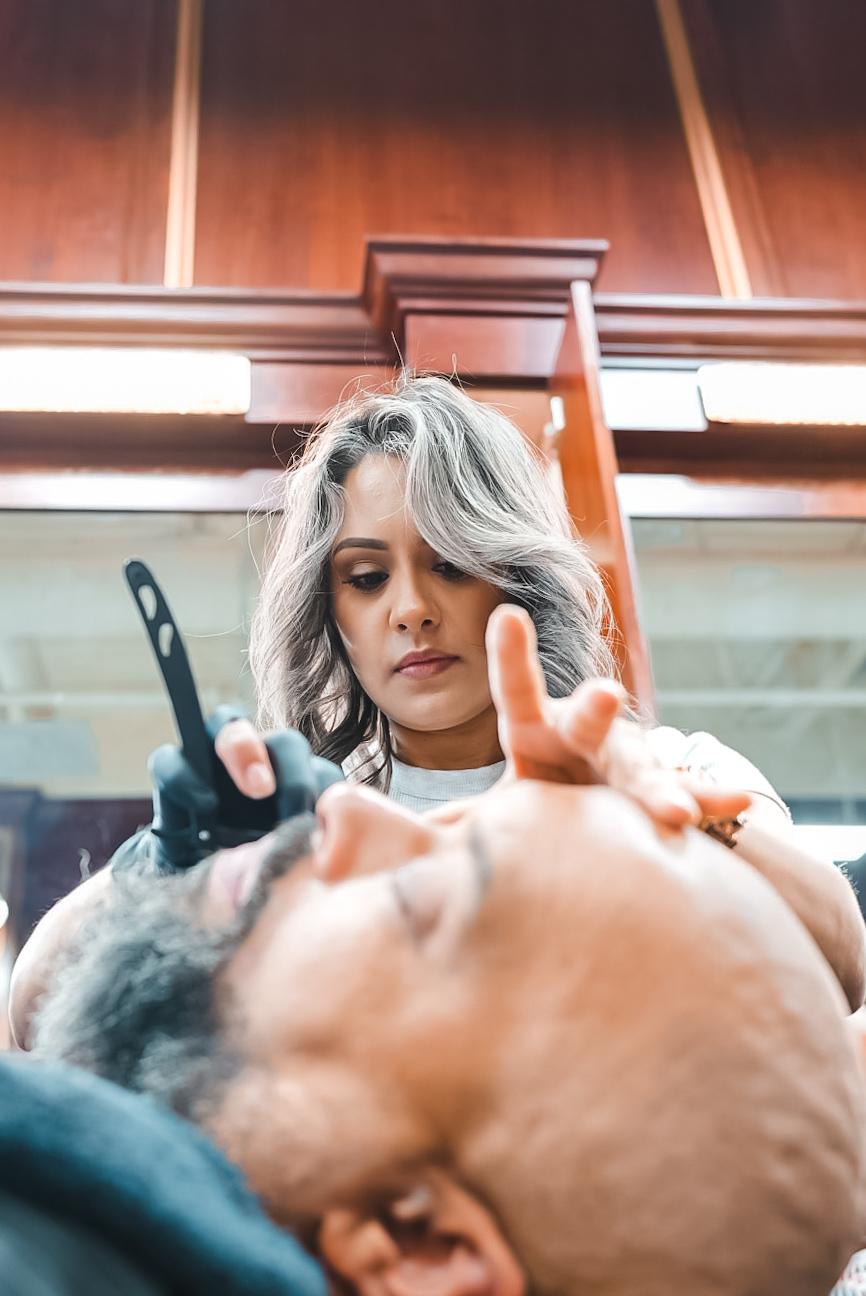 Famous Fadez barber shaping a client’s hairline with precision
