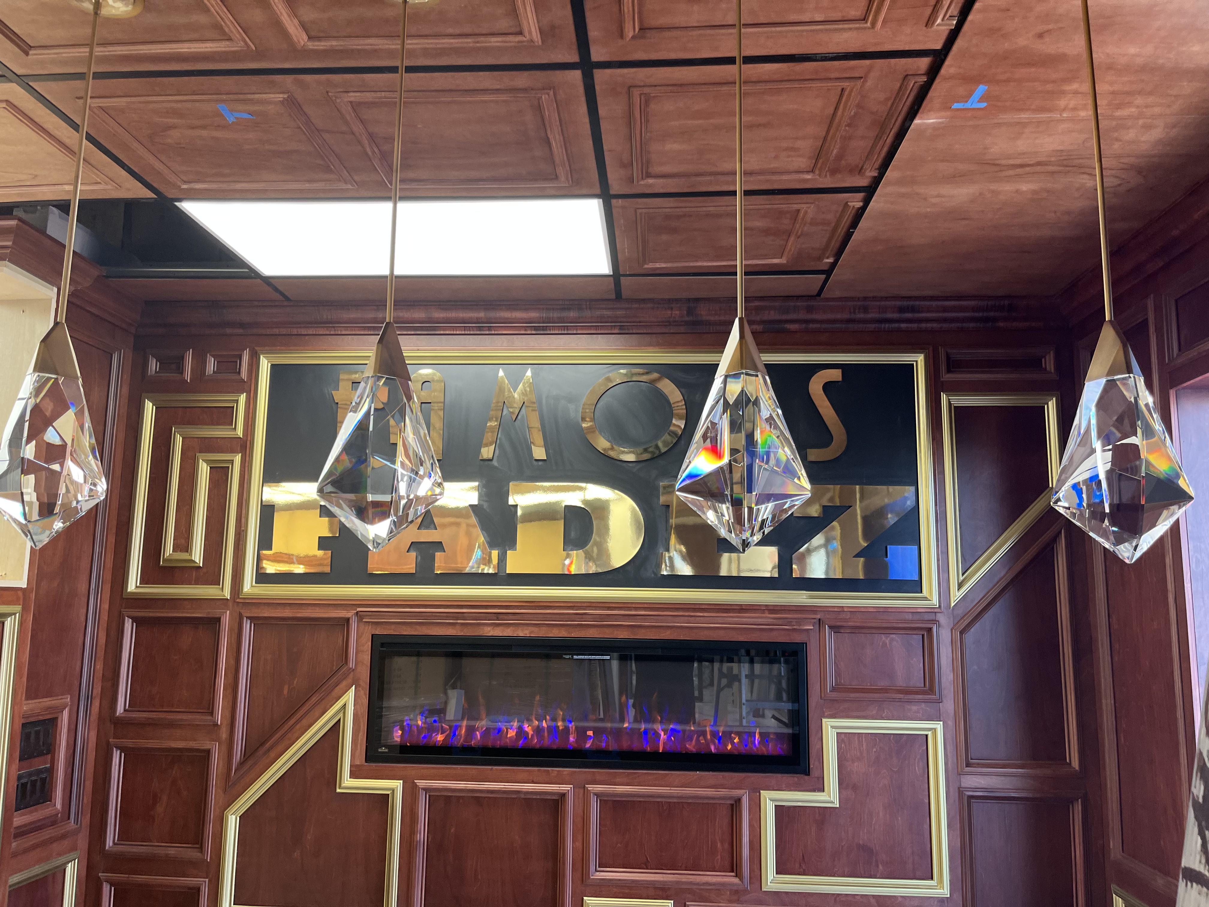 Famous Fadez gold sign above a warm fireplace